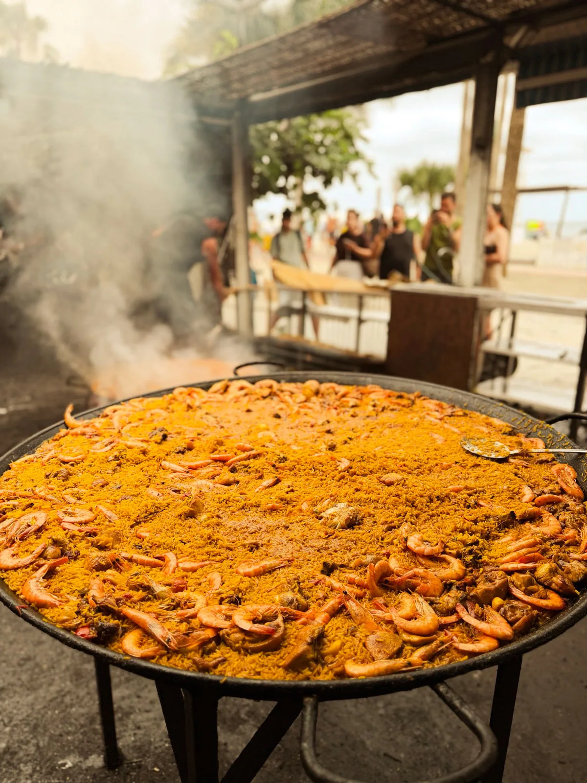 Paella gigante cocinada a la leña en la arena de Burriana